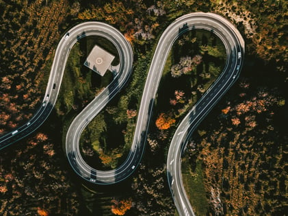 aerial-view-of-winding-curved-road-with-helipad-an-2022-01-18-23-55-25-utc