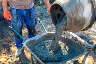 builder-pouring-cement-from-a-cement-mixer-2022-12-16-12-36-28-utc