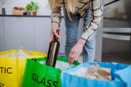 midsection-of-woman-throwing-empty-glass-bottle-in-2022-03-26-11-20-01-utc