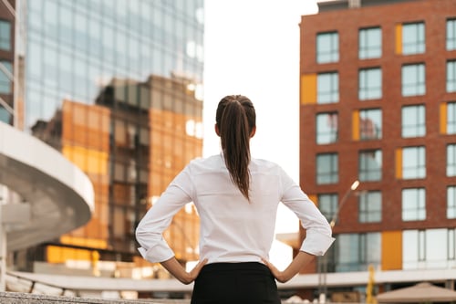 rear-view-of-businesswoman-looking-business-buildi-2024-10-18-06-45-17-utc